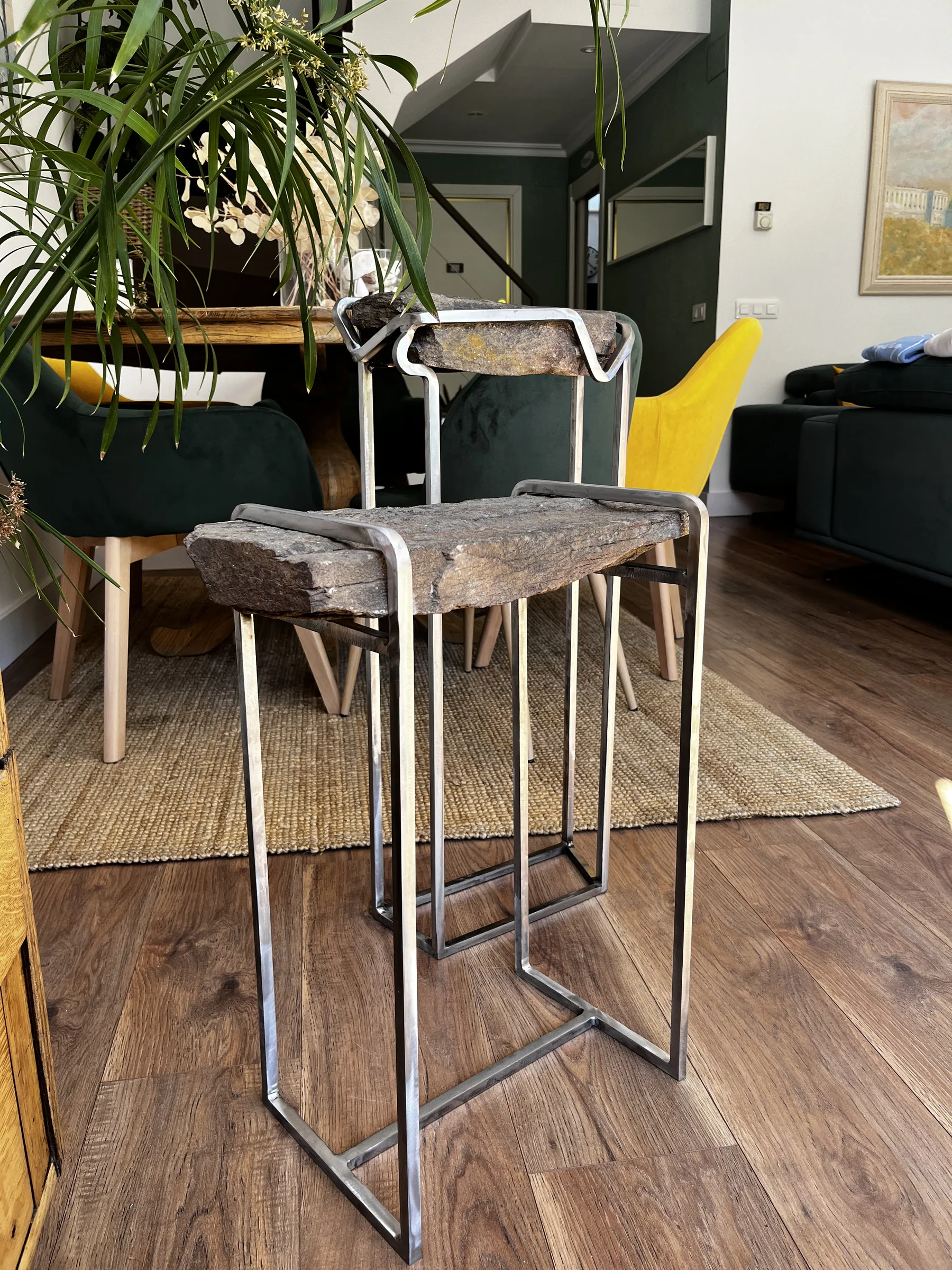 Mesa auxiliar artesanal de metal y acabado pétreo en un interior