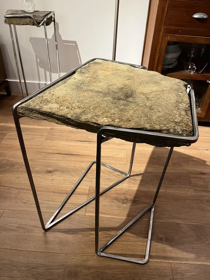 Detalle de una mesa auxiliar de metal y superficie pétrea; fotografía 1 de esta serie