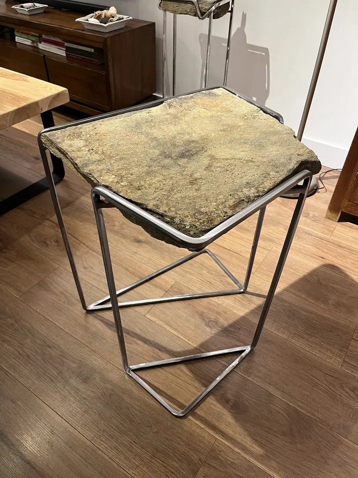 Detalle de una mesa auxiliar de metal y superficie pétrea; fotografía 2 de esta serie