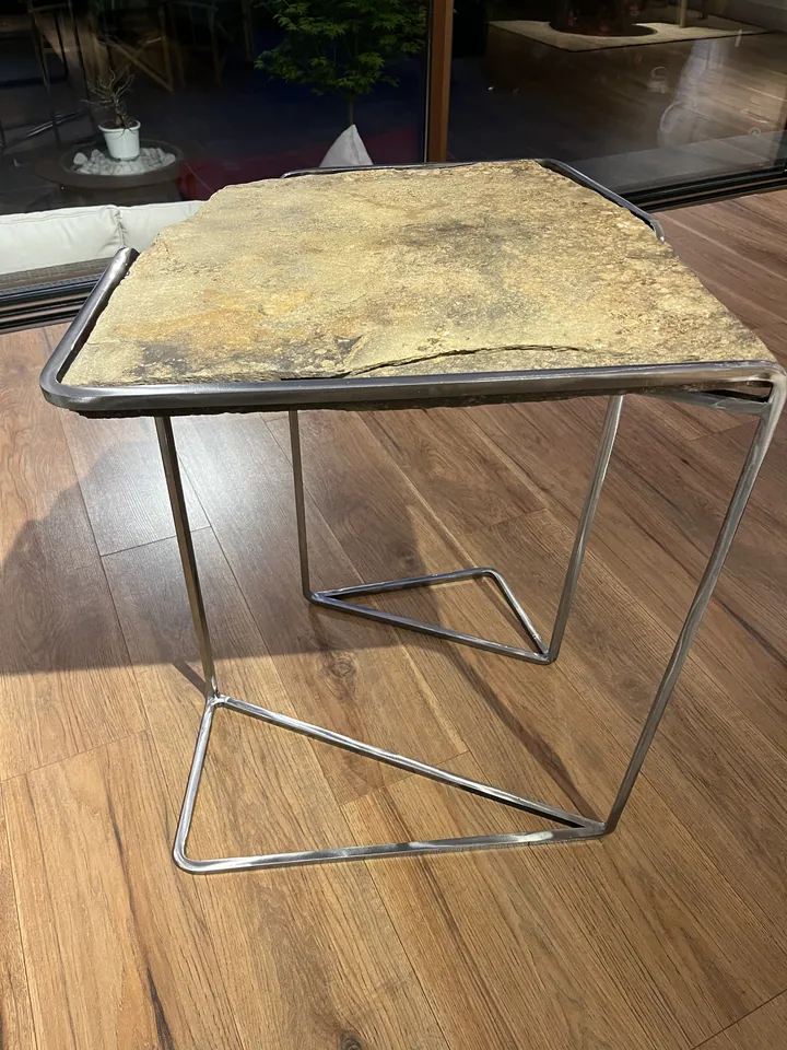 Detalle de una mesa auxiliar de metal y superficie pétrea; fotografía 3 de esta serie