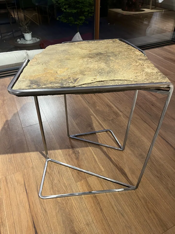 Detalle de una mesa auxiliar de metal y superficie pétrea; fotografía 4 de esta serie