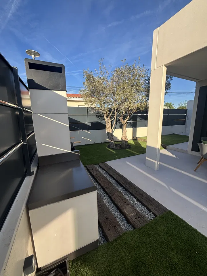 Jardín contemporáneo junto a una casa blanca